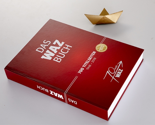 Rotes WAZ Buch mit Papierboot